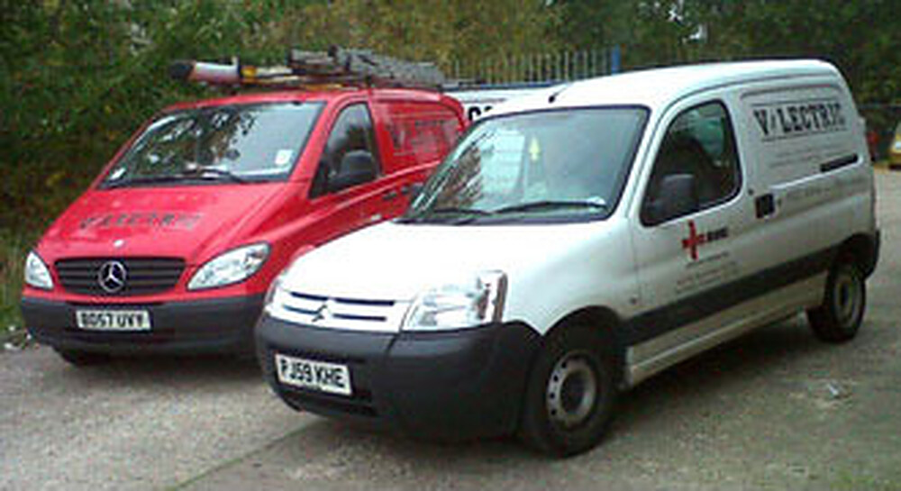 Two liveried V-lectric vans, one red and one white